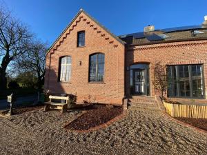 une maison en briques avec un banc devant elle dans l'établissement Villa Nordic, à Dornum