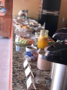 a buffet with food and drinks on a counter at Pousada Flor de Pequi in Serra do Cipo