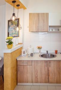 a kitchen with wooden cabinets and a sink at Apartman Mia in Sremska Mitrovica