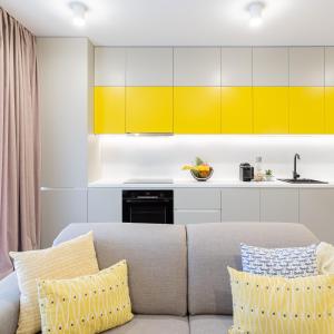 uma sala de estar com um sofá e armários amarelos em Il Lago - Sunrise - Cozy Luxurious Smart Home By The Lake em Voluntari