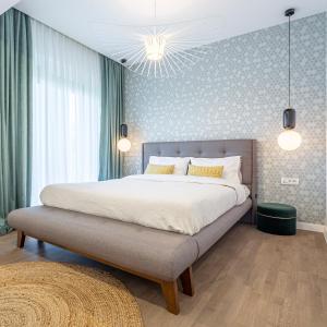 Un dormitorio con una cama grande con una gran colcha blanca en Il Lago - Sunrise - Cozy Luxurious Smart Home By The Lake, en Voluntari