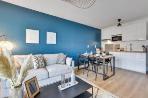 a living room with a white couch and a blue wall at Splendid 2br w parking in Montévrain nearby Disneyland Paris - Welkeys in Montévrain