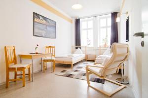 a living room with a table and chairs at Pension Piano Forte Leipzig Mitte in Leipzig