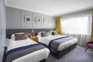 um quarto de hotel com duas camas e uma janela em Hotel Imperial Dundalk em Dundalk