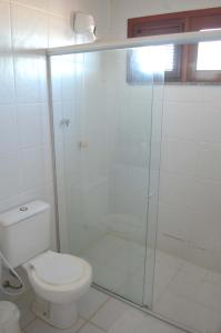 a bathroom with a toilet and a glass shower at Aqua Villa by Garvetur in Beberibe +22 photos
