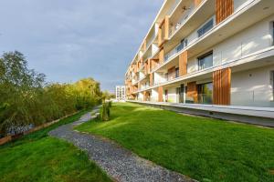 an external view of a building with a grass yard at Il Lago - Azur - Cozy Luxurious Smart Home By The Lake in Voluntari