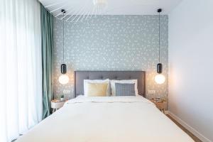 a bedroom with a large white bed and a blue wall at Il Lago - Azur - Cozy Luxurious Smart Home By The Lake in Voluntari