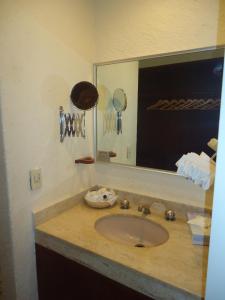 a bathroom with a sink with a mirror and a counter at Hotel Las Torres Gemelas Acapulco in Acapulco