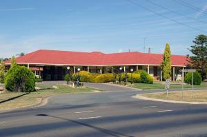 a building with a red roof on a street at Pines Country Club Motor Inn in Shepparton