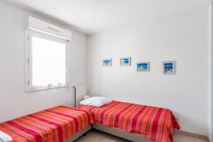 una camera bianca con un letto e una finestra di Calm and sunny AC house with terrace and garden in Antibes - Welkeys a Antibes