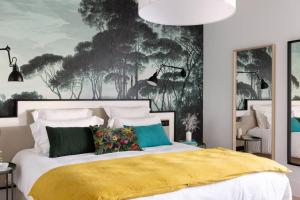 um quarto com uma cama grande e um cobertor amarelo em Dinard, très bel appartement***** avec vue sur mer em Dinard