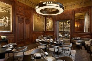 un restaurant avec des tables et des chaises et un lustre dans l'établissement Maison Villeroy, à Paris