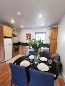 a kitchen with a black table with chairs and a vase at Milligan Court Townhouses in Sligo