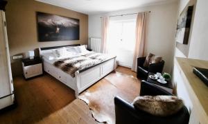 キッツビュールにあるKitzbühel Apartments Haus Bruggerのベッドルーム1室(ベッド1台、ソファ、椅子付)