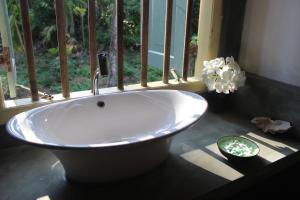 a white tub in a bathroom with a window at The Spice House Mirissa in Mirissa