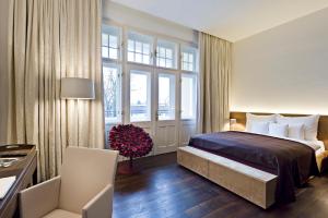 
a bedroom with a large bed and a large window at Hotel Steirerschlössl in Zeltweg
