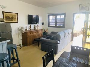 ein Wohnzimmer mit einem Sofa und einem TV in der Unterkunft Casas Rita in Frontera