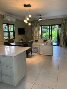 a kitchen and living room with a couch and a table at Water Mills- Beach Apartments in Mammee Bay