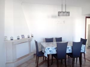 a dining room with a table and blue chairs at Tavira Garden in Tavira