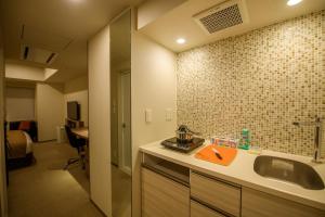 a bathroom with a sink and a room with a bed at Tokyu Stay Ginza in Tokyo