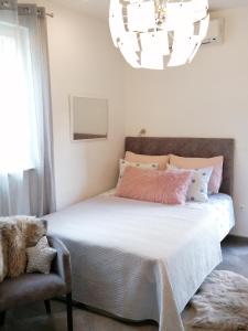a bedroom with a large bed and a chandelier at Apartments Iris in Hvar