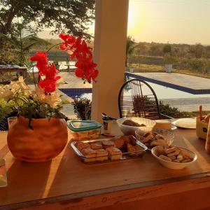 a table with a tray of food and flowers on it at Pousada Terra de Minas in Sacada