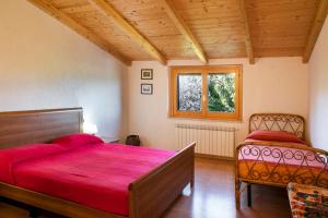 Un dormitorio con una gran cama roja y una ventana en Casale Mi Cantino, en Bevagna
