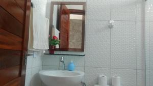 a white bathroom with a sink and a mirror at Casa do Tchesko in Viçosa do Ceará +15 photos