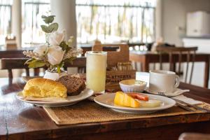 a wooden table with plates of breakfast foods on it at Pousada Numei de Jeri in Jericoacoara