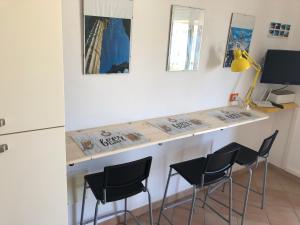 uma cozinha com um balcão com cadeiras e uma secretária em Tonnara Apartments em Alcamo Marina