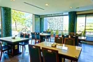 - un restaurant avec des tables, des chaises et de grandes fenêtres dans l'établissement Boutique Hot Spring Resort, à Xindian