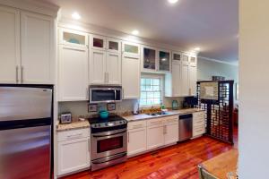 a kitchen with white cabinets and stainless steel appliances at 1 Francis in Charleston