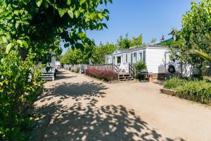 a house with a fence and a dirt road at Camping Tucan - Mobile Homes by Lifestyle Holidays in Lloret de Mar