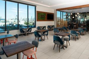 a restaurant with tables and chairs and large windows at Hyatt Place Chicago Wicker Park in Chicago