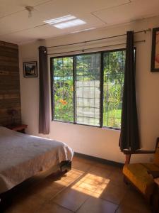a bedroom with a bed and a window at Airport Rio Segundo Studio in Alajuela
