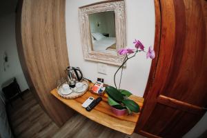 a table with a mirror and a flower on it at Botánica Iguazú The House Experience in Puerto Iguazú