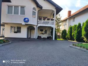 a driveway in front of a white house at Apartments Airport Inn in Dubrave Gornje