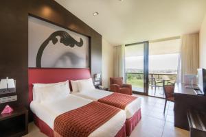 a hotel room with a bed and a large window at Hotel Mas Solà in Santa Coloma de Farners