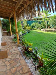 a garden with a patio with a grass yard at Manaeva lodge in Faaa