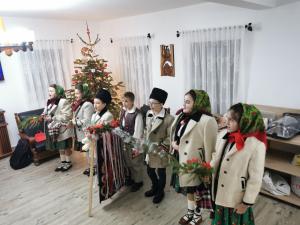 a group of children standing in front of a christmas tree at Maramures Landscape in Moisei