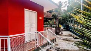 a red house with a white door on the side of it at Pousada Mama África in Conservatória