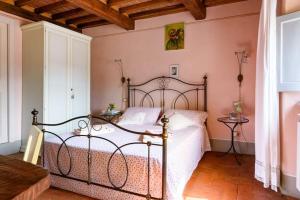 een slaapkamer met een bed in een kamer met roze muren bij Casa Clara Cortona in Cortona