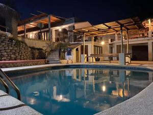 a person walking by a swimming pool at night at Villa Paraíso in La Ventana