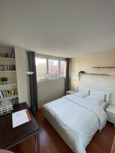 a bedroom with a white bed and a desk and window at Chambre calme (Mars) - proche Paris et TGV in Massy