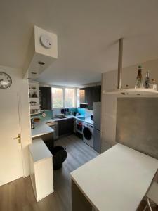 une cuisine avec des comptoirs blancs et un comptoir blanc dans l'établissement Chambre calme (Mars) - proche Paris et TGV, à Massy