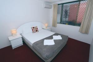 a bedroom with a bed with two towels on it at St Tropez Resort in Gold Coast