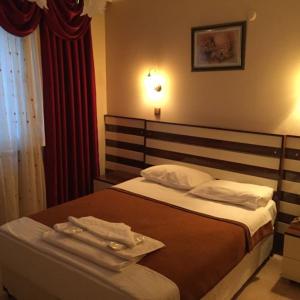 1 dormitorio con 1 cama con 2 toallas en Isık Hotel, en Edirne