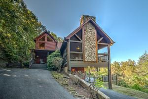 a house with a wrap around porch and a driveway at Pinecone Peak in Mineral Bluff