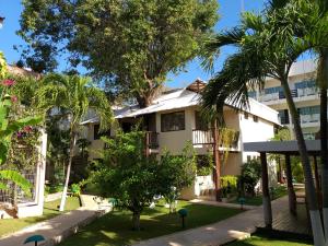 a building with palm trees in front of it at Posada Sian Kaan Playa del Carmen - Wellness Oriented Hotel in Playa del Carmen