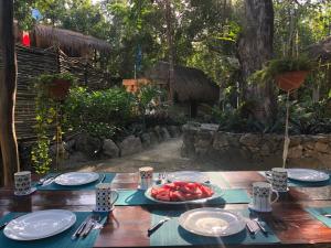 a wooden table with a plate of fruit on it at Casa Tzalam Tulum selva in Tulum